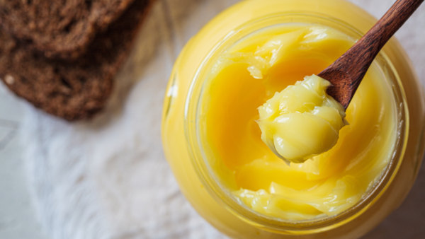 Golden ghee being poured, a healthy fat source